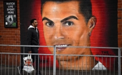 A pedestrian walks past a mural of Manchester United's Cristiano Ronaldo, near Old Trafford stadium, home ground of Manchester United football team in Manchester on November 23, 2022.   (Photo by Oli SCARFF / AFP)