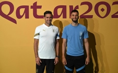 Uruguay's coach Diego Alonso (left) and Rodrigo Bentancur pose for a picture as they arrive to give a press conference at the Qatar National Convention Center (QNCC) in Doha on November 27, 2022. (Photo by Pablo PORCIUNCULA / AFP)