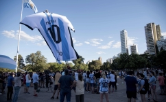 Fans look at a giant jersey of Argentinian forward Lionel Messi displayed in Rosario, Argentina: AFP/Marcelo Manera