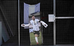 A poster with the image of Argentine football star Lionel Messi is seen in the gate of a store prior of the Qatar 2022 World Cup final football match between Argentina and France in Buenos Aires, on December 16, 2022. (Photo by Luis ROBAYO / AFP)