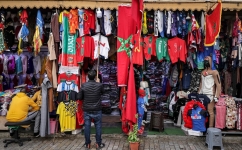 A shop keeper hangs a football jersey at a sports apparel shop in Morocco's capital Rabat on December 13, 2022 a day ahead of the FIFA World Cup semi-final match between Morocco and France. (Photo by FADEL SENNA / AFP)