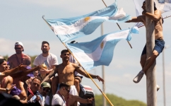 A fan of Argentina clinging to a pole cheers as the team parades on board a bus after winning the Qatar 2022 World Cup tournament, in Buenos Aires province, on December 20, 2022.  (Photo by TOMAS CUESTA / AFP)