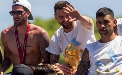 Lionel Messi (centre) celebrates with teammates on board a bus with a sign reading "World Champions"  as they tour through Buenos Aires' downtown on December 20, 2022.  (Photo by TOMAS CUESTA / AFP)