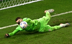 Croatia's Dominik Livakovic saves the second penalty shoot-out by Japan's Kaoru Mitoma during the Qatar 2022 World Cup round of 16 match at the Al-Janoub Stadium in Al-Wakrah on December 5, 2022. (Photo by Anne-Christine POUJOULAT / AFP)
