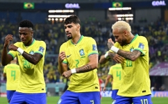 Brazil's Vinicius Jnr celebrates scoring his team's first goal with Lucas Paqueta and Neymar during the Qatar 2022 World Cup round of 16 match against South Korea at Stadium 974 in Doha on December 5, 2022. (Photo by MANAN VATSYAYANA / AFP)