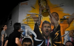 A mural by artist Maxi Bagnasco depicting Argentina's captain Lionel Messi raising trophy next to his teammates after winning the Qatar 2022 World Cup tournament is seen in Buenos Aires on December 22, 2022. (Photo by Luis ROBAYO / AFP)