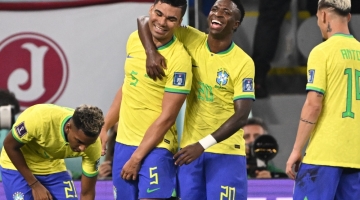 Brazil's Casemiro (centre) celebrates with his teammate Vinicius Junior after he scored his team's goal during the Qatar 2022 World Cup Group G match against Switzerland at Stadium 974 in Doha on November 28, 2022. (Photo by Fabrice COFFRINI / AFP)