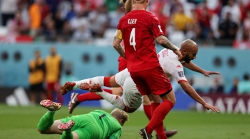 Tunisia's forward Issam Jebali (R) goes down during the Qatar 2022 World Cup Group D football match between Denmark and Tunisia at the Education City Stadium in Al-Rayyan, west of Doha on November 22, 2022. (Photo by ADRIAN DENNIS / AFP)