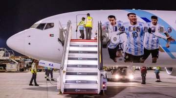 Members of the Argentinian team peer out from the windows of their plane adorned with a picture of Lionel Messi and team-mates as they arrive at the Hamad International Airport in Doha on November 17: AFP/Odd Andersen
