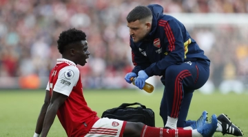 Arsenal's English midfielder Bukayo Saka speaks to member of the medical staff after picking up an injury during the English Premier League football match between Arsenal and Nottingham Forest at the Emirates Stadium in London on October 30, 2022.