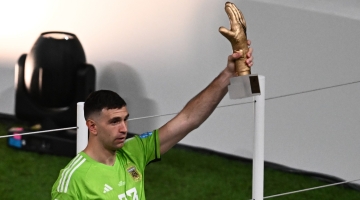 Argentina's goalkeeper Emiliano Martinez poses for pictures holding the Golden Glove award trophy at the end of the Qatar 2022 World Cup final at Lusail Stadium in Lusailon December 18, 2022. (Photo by Jewel SAMAD / AFP)