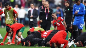 Moroccan players pray and thank the crowd after losing to France in the semifinal: AFP/Adrian Dennis