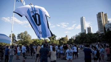 Fans look at a giant jersey of Argentinian forward Lionel Messi displayed in Rosario, Argentina: AFP/Marcelo Manera