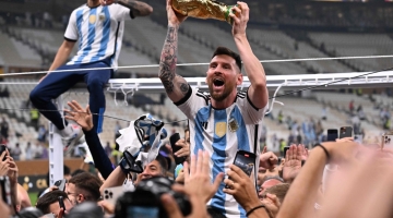 Argentina's Lionel Messi lifts the FIFA World Cup Trophy as he celebrateswith supporters after winning the Qatar 2022 World Cup at Lusail Stadium in Lusail on December 18, 2022. (Photo by Kirill KUDRYAVTSEV / AFP)