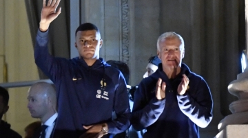France's forward Kylian Mbappe (left) and coach Didier Deschamps greet supporters at the Hotel de Crillon, a day after the Qatar 2022 World Cup final match Place de la Concorde in central Paris on December 19, 2022. (Photo by JULIEN DE ROSA / AFP)