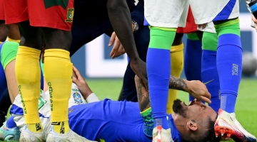 Brazil's defender Alex Telles reacts after picking up an injury during the Qatar 2022 World Cup Group G match against Cameroon at the Lusail Stadium in Lusai, Doha, on December 2, 2022. (Photo by Issouf SANOGO / AFP)