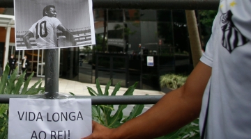 Fans place a picture of Brazilian legend Pele and a sign reading 'Long Life to the King!" outside the hospital entrance, where he is hospitalised in Sao Paulo, Brazil, on December 4, 2022. (Photo by Miguel Schincariol / AFP)