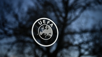 A picture taken on February 28, 2020 shows a UEFA sign through a window at the headquarters of the European football's governing body in Nyon. / AFP / FABRICE COFFRINI