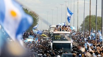 Fans of Argentina cheer as the team parades on board a bus after winning the Qatar 2022 World Cup tournament, in Buenos Aires province, on December 20, 2022.  (Photo by TOMAS CUESTA / AFP)