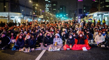 Fans of South Korea react as they watch the Qatar 2022 World Cup Round of 16 football match between Brazil and South Korea on a big screen as it snows in Seoul, on December 6, 2022. (Photo by Anthony WALLACE / AFP)
