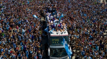 Argentina's players celebrate on board a bus with a sign reading "World Champions" with supporters after winning the Qatar 2022 World Cup as they tour through Buenos Aires' on December 20, 2022.  (Photo by TOMAS CUESTA / AFP)