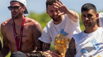Lionel Messi (centre) celebrates with teammates on board a bus with a sign reading "World Champions"  as they tour through Buenos Aires' downtown on December 20, 2022.  (Photo by TOMAS CUESTA / AFP)