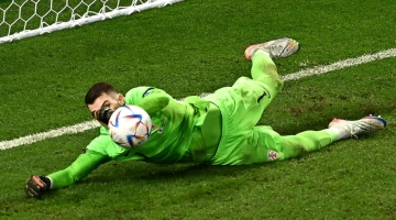 Croatia's Dominik Livakovic saves the second penalty shoot-out by Japan's Kaoru Mitoma during the Qatar 2022 World Cup round of 16 match at the Al-Janoub Stadium in Al-Wakrah on December 5, 2022. (Photo by Anne-Christine POUJOULAT / AFP)