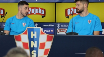 Croatia's Bruno Petkovic (right) speaks to teammate Josip Juranovic during a press conference in Doha on December 11, 2022, ahead of their Qatar 2022 semi-final match against Argentina. (Photo by JACK GUEZ / AFP)