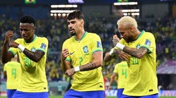 Brazil's Vinicius Jnr celebrates scoring his team's first goal with Lucas Paqueta and Neymar during the Qatar 2022 World Cup round of 16 match against South Korea at Stadium 974 in Doha on December 5, 2022. (Photo by MANAN VATSYAYANA / AFP)