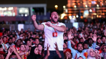 Morocco's supporters celebrate after their team won the Qatar 2022 World Cup round 16 match against Spain, at the FIFA fan zone in Doha, on December 6, 2022. (Photo by MAHMUD HAMS / AFP)