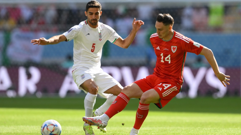 Iran’s Milad Mohammadi, left, and Wales’ Connor Roberts battle for the ball: AFP/Nicolas Tucat