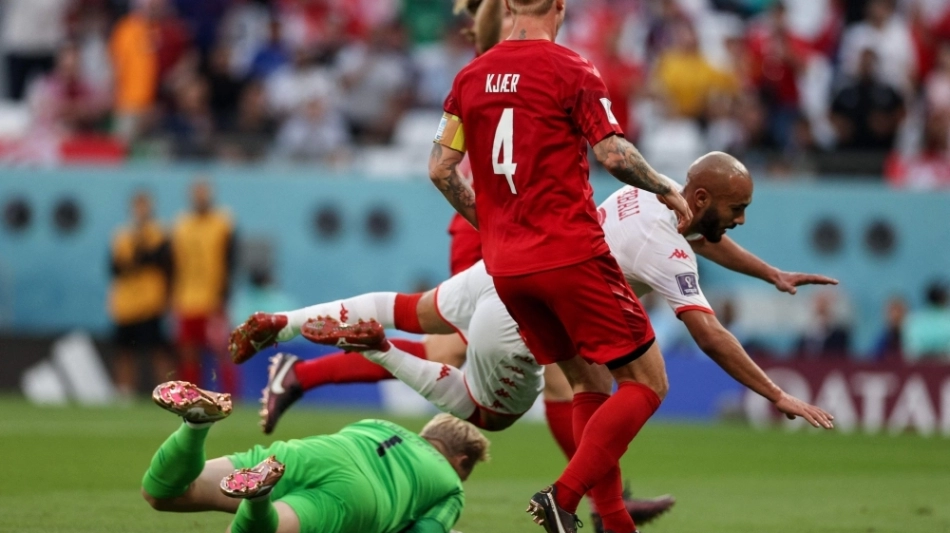 Tunisia's forward Issam Jebali (R) goes down during the Qatar 2022 World Cup Group D football match between Denmark and Tunisia at the Education City Stadium in Al-Rayyan, west of Doha on November 22, 2022. (Photo by ADRIAN DENNIS / AFP)