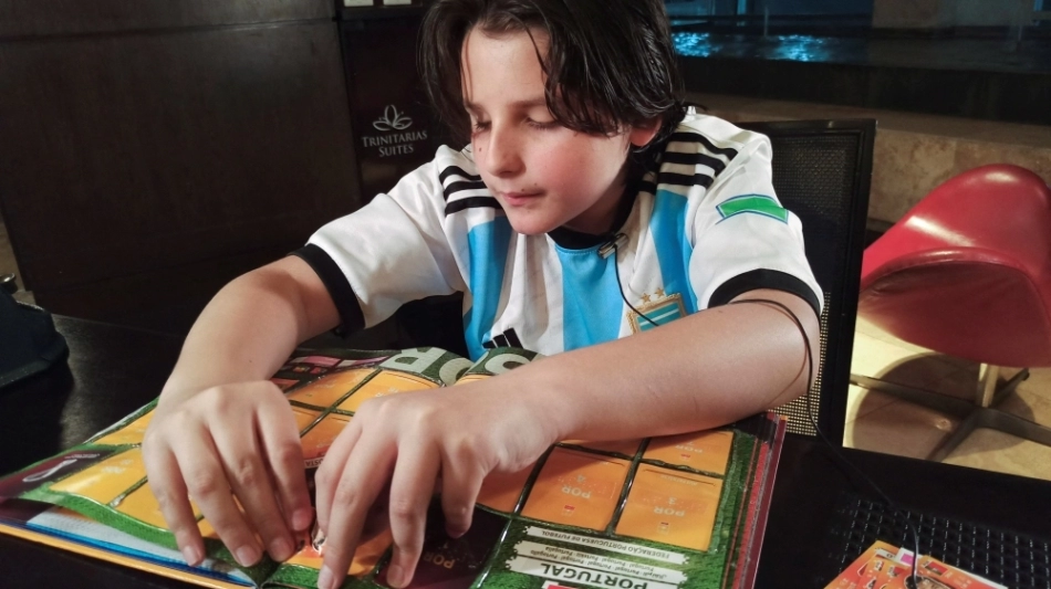 Sebastian Filoramo, 12, a visually impaired boy who adapted the FIFA World Cup Qatar 2022 Panini card album to Braille, checks his album in Barquisimeto, Venezuela, on November 8, 2022. REUTERS