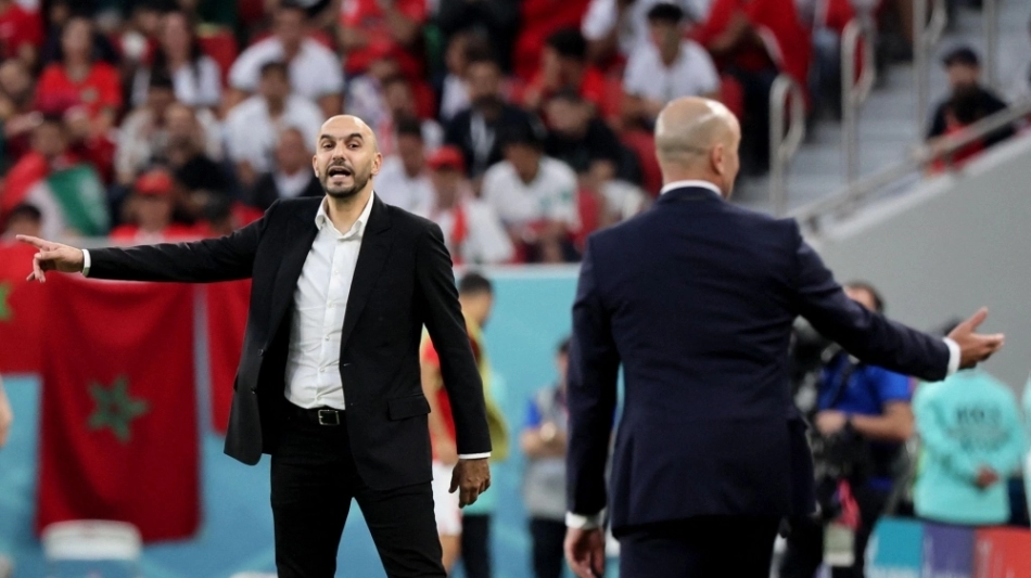 Morocco's coach Walid Regragui (left) gestures to his players from the touchline during their Qatar 2022 World Cup Group F match at the Al-Thumama Stadium in Doha on November 27, 2022. (Photo by JACK GUEZ / AFP)