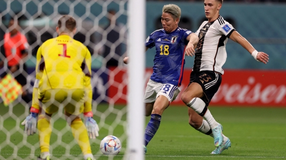 Japan's forward Takuma Asano (center) shoots to score his team's second goal during the Qatar 2022 World Cup Group E match against Germany at the Khalifa International Stadium in Doha on November 23, 2022. (Photo by Adrian DENNIS / AFP)