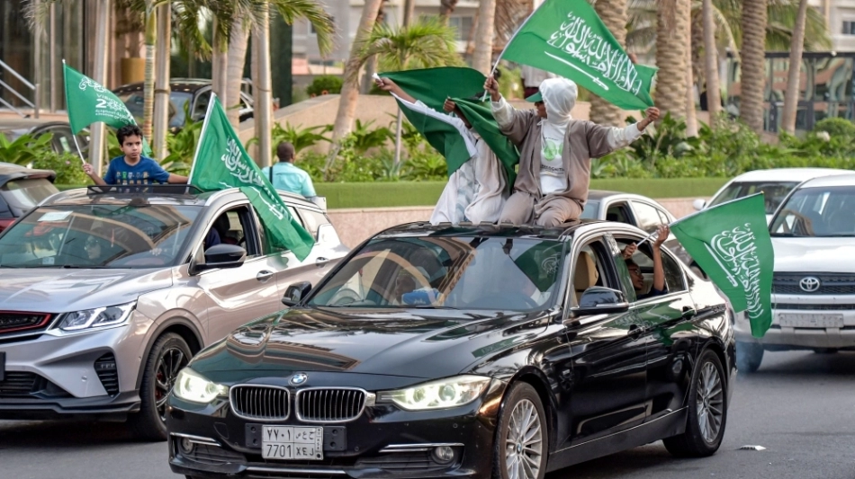 Saudi football fans wave their country's flags from vehicles as they celebrate their win over Argentina in the Qatar 2022 World Cup on November 22, 2022. (Photo by Amer HILABI / AFP)