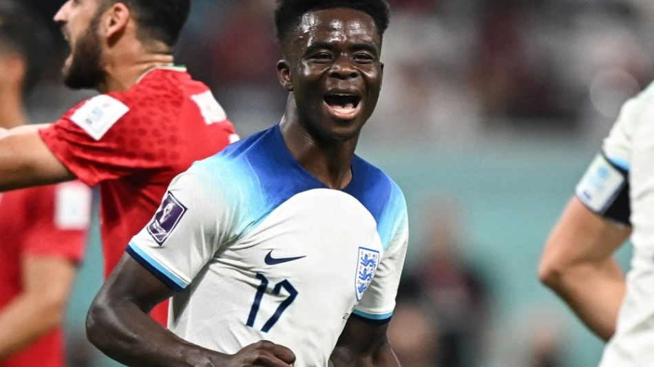 England's forward #17 Bukayo Saka celebrates scoring his team's fourth goal during the Qatar 2022 World Cup Group B football match between England and Iran at the Khalifa International Stadium in Doha on November 21, 2022. (Photo by Paul ELLIS / AFP)