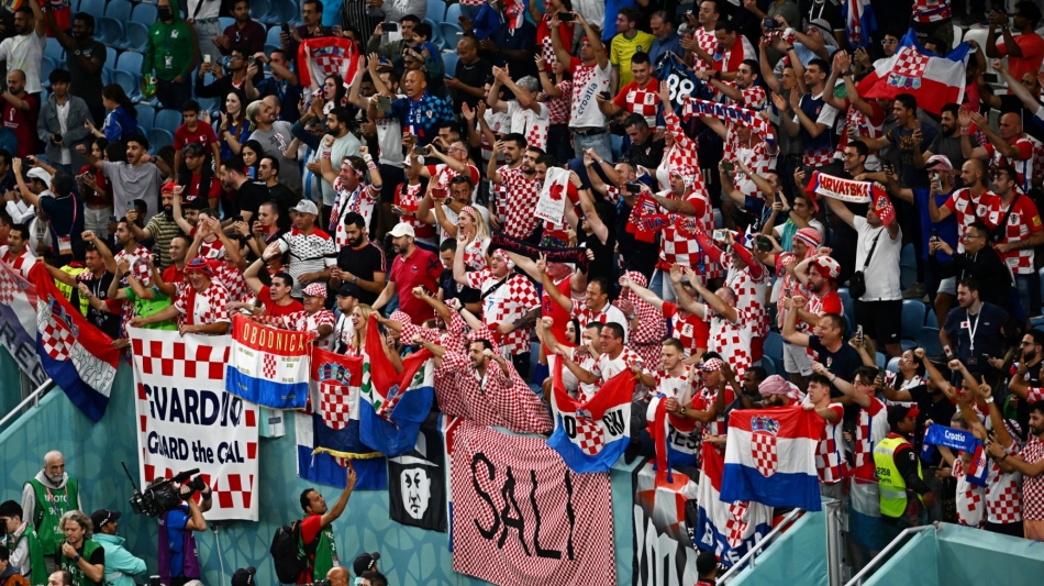 Croatia supporters celebrate after their team won the Qatar 2022 World Cup round of 16 match against Japan at the Al-Janoub Stadium in Al-Wakrah, south of Doha on December 5, 2022. (Photo by Anne-Christine POUJOULAT / AFP)