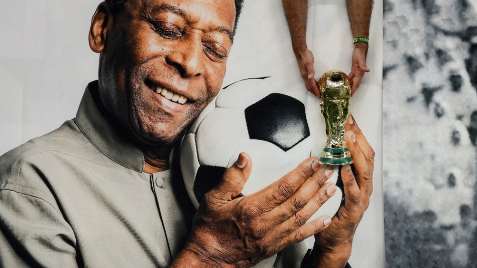 Brazil fan holds a replica World Cup trophy in front of a banner of former Brazil player Pele before the Cameroon v Brazil match at Lusail Stadium, Lusail, Qatar on December 2, 2022 REUTERS/Benoit Tessier/File Photo