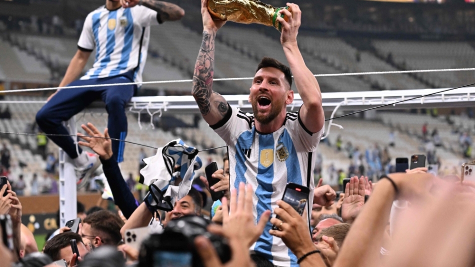 Argentina's Lionel Messi lifts the FIFA World Cup Trophy as he celebrateswith supporters after winning the Qatar 2022 World Cup at Lusail Stadium in Lusail on December 18, 2022. (Photo by Kirill KUDRYAVTSEV / AFP)