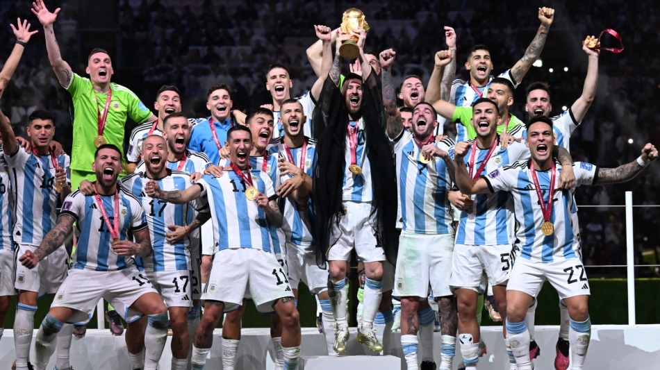 Argentina's captain Lionel Messi (centre) lifts the FIFA World Cup Trophy as he celebrate with teammates at Lusail Stadium in Lusail, north of Doha on December 18, 2022. (Photo by Kirill KUDRYAVTSEV / AFP)