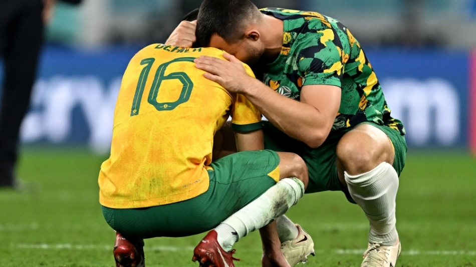 Australia's defender #16 Aziz Behich is comforted by a teammate after losing to Argentina in the Qatar 2022 World Cup round of 16 match at the Ahmad Bin Ali Stadium in Al-Rayyan on December 3, 2022. (Photo by MANAN VATSYAYANA / AFP)