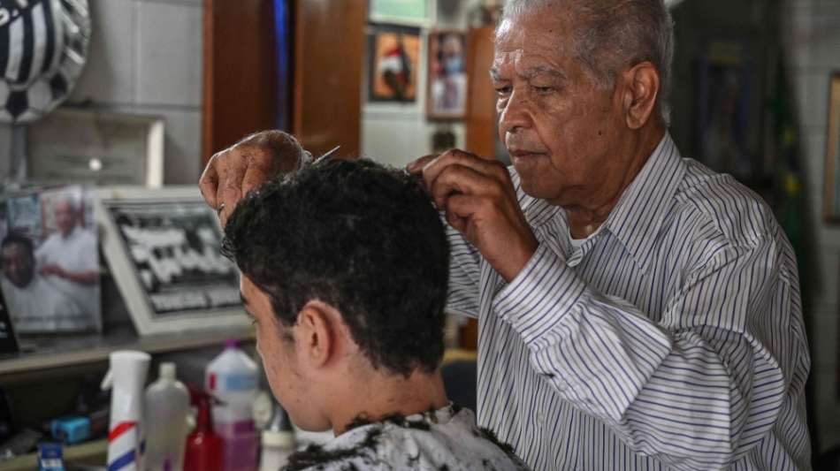 Barber Joao Araujo, known as Didi, who cut Brazilian football legend Pele's hair, works in his hairdressing salon in Santos, Brazil, on December 30, 2022. (Photo by Nelson ALMEIDA / AFP)