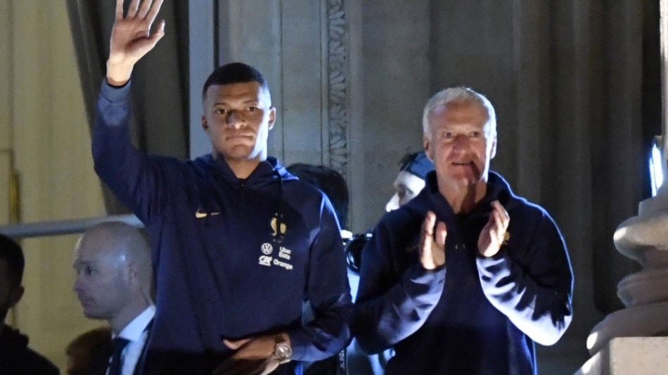 France's forward Kylian Mbappe (left) and coach Didier Deschamps greet supporters at the Hotel de Crillon, a day after the Qatar 2022 World Cup final match Place de la Concorde in central Paris on December 19, 2022. (Photo by JULIEN DE ROSA / AFP)