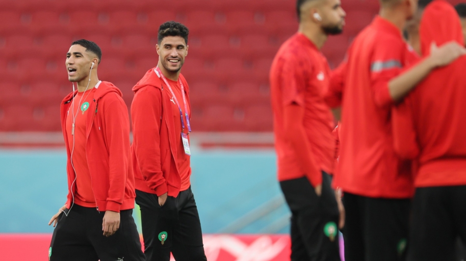 Morocco's defender Achraf Hakimi (left) with teammates inspect the pitch ahead of the Qatar 2022 quarter-final match against Portugal at the Al-Thumama Stadium in Doha on December 10, 2022. (Photo by KARIM JAAFAR / AFP)