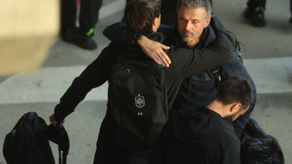 Spain's coach Luis Enrique (right) hugs assistant coach Aitor Unzue upon the team's  arrival at the Adolfo Suarez Madrid-Barajas airport on the outskirts of Madrid on December 7, 2022. (Photo by Thomas COEX / AFP)