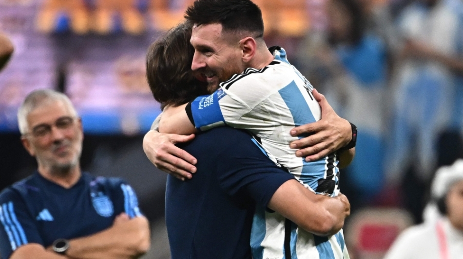 Lionel Messi celebrates with coach Lionel Scaloni  after Argentina won the Qatar 2022 World Cup final match against France at Lusail Stadium in Lusail, north of Doha on December 18, 2022. (Photo by Anne-Christine POUJOULAT / AFP)