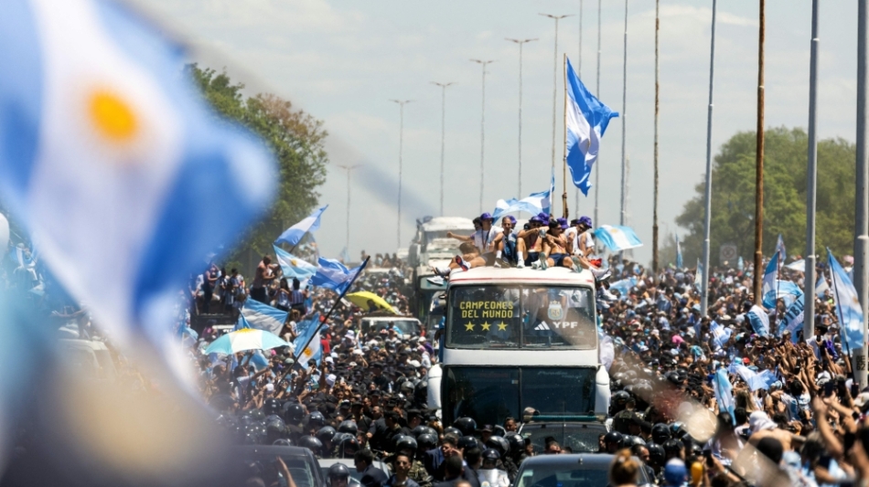 Fans of Argentina cheer as the team parades on board a bus after winning the Qatar 2022 World Cup tournament, in Buenos Aires province, on December 20, 2022.  (Photo by TOMAS CUESTA / AFP)