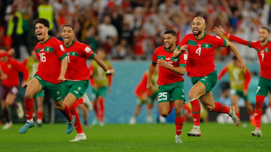 Morocco players celebrate after they won on penalty shoot-out the Qatar 2022 World Cup round of 16 football match agaisnt Spain at the Education City Stadium in Al-Rayyan, west of Doha, on December 6, 2022. (Photo by Odd ANDERSEN / AFP)