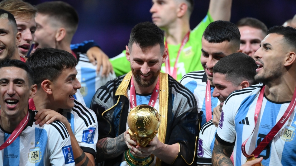 Lionel Messi looks at the World Cup trophy during the Qatar 2022 World Cup trophy ceremony after the final match against France at Lusail Stadium in Lusail on December 18, 2022. (Photo by FRANCK FIFE / AFP)